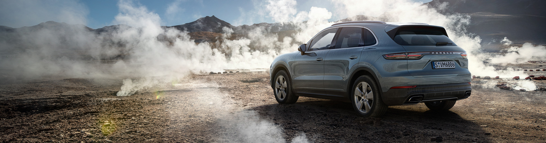 Porsche Cayenne i öken omgiven av rök.